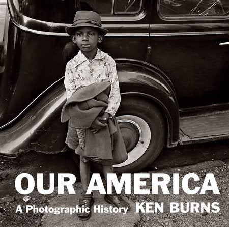 Black and white photo of a young boy standing in front of a vehicle with 'Our America' and 'Ken Burns' text.