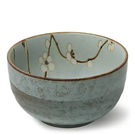 Soft blue ceramic bowl with a white and brown floral design on a white background