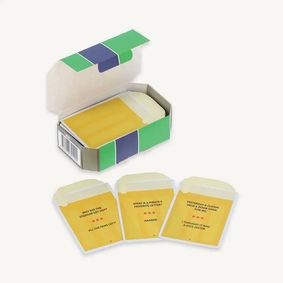 Open box of yellow joke cards with text on a white background