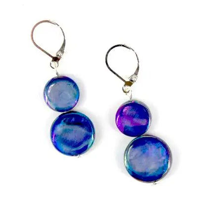 Pair of earrings with blue and purple circular mother of pearl stones on a white background