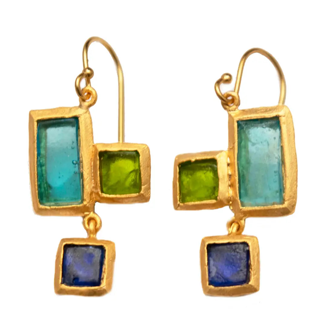 Gold earrings with green and blue glass squares on a white background