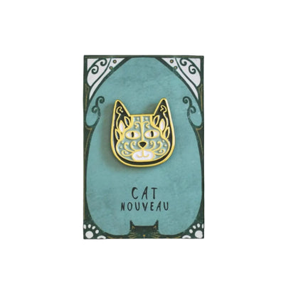 Gold cat-shaped pin on a teal card with 'Cat Nouveau' text against a teal background