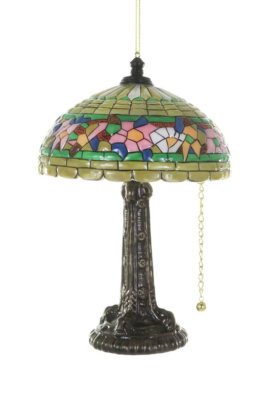Tiffany lamp glass ornament with a bronze base a multi-color stained glass shade with a bronze finial and a gold metal chain on a white background.