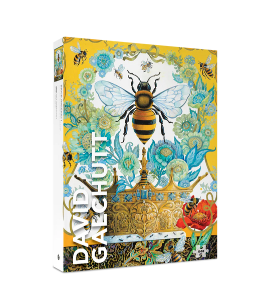 Jigsaw puzzle box with an artwork by David Galburt featuring a bee and crown on a yellow and white background with blue flowers 
