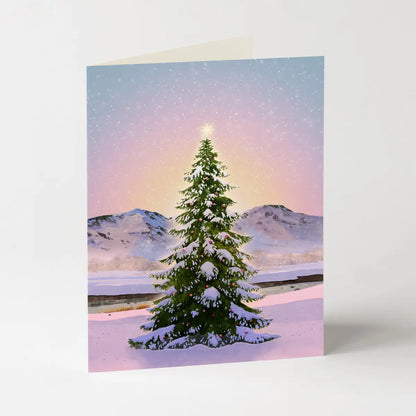 A card featuring a green Christmas tree against a pastel landscape on a light grey background
