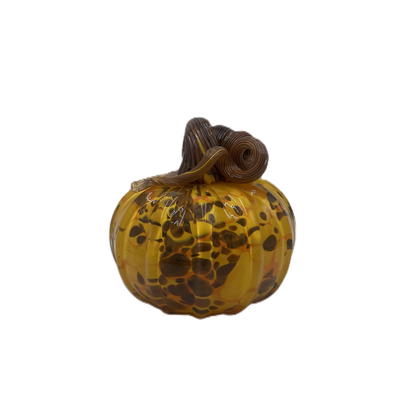 A small decorative glass pumpkin with a marbled amber-yellow body, dark brown and orange speckles, and a dark brown stem, isolated on a white background.