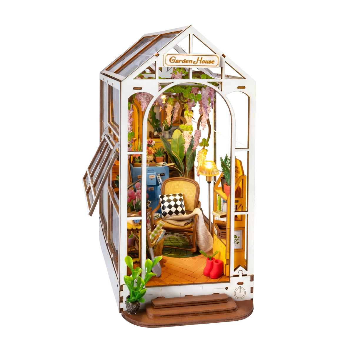 A miniature wooden greenhouse with plants and a chair inside on a white background.