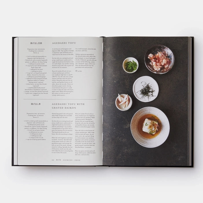 Open cookbook showing a recipe for Agedashi Tofu with ingredients on a dark surface.