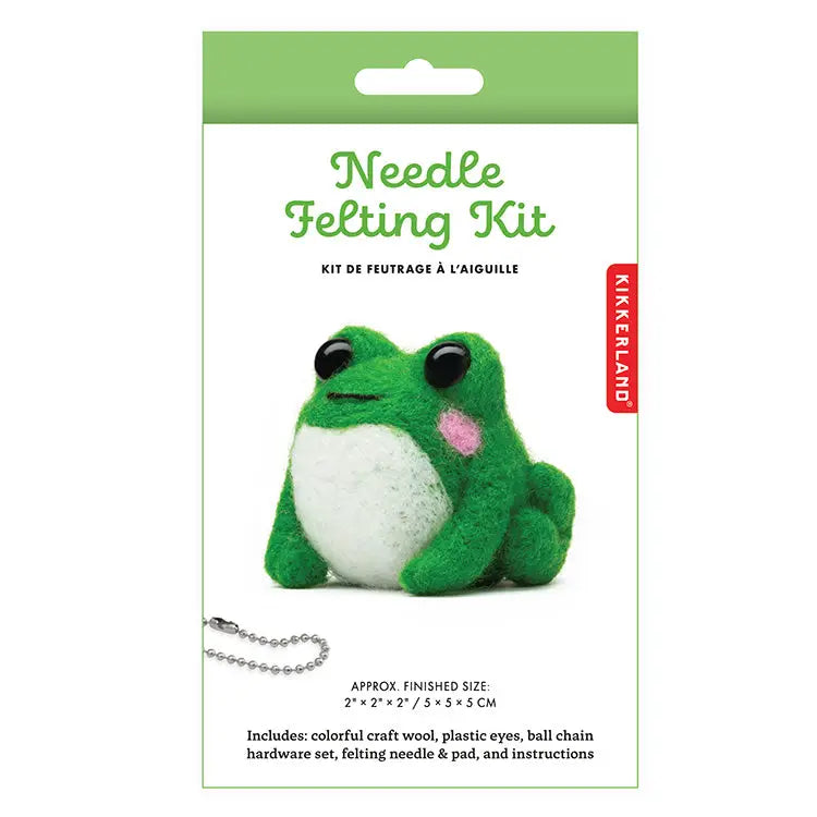 Product packaging for a 'Needle Felting Kit'. The front features a green felted frog with a white belly, black eyes and pink cheeks. Shown on a white background.