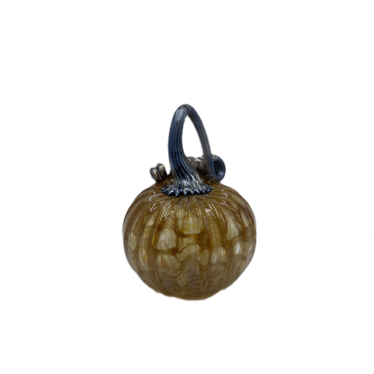 A small decorative glass pumpkin with a ribbed textured body in amber-brown and cream tones, featuring a dark blue-stem and loop handle, isolated on a white background.