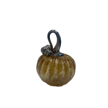 A small decorative glass pumpkin with a ribbed textured body in amber-brown and cream tones, featuring a dark blue-stem and loop handle, isolated on a white background.