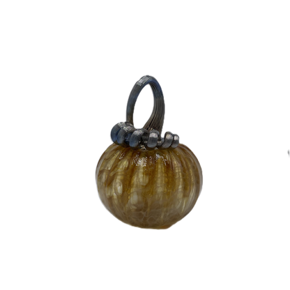 A small decorative glass pumpkin with a ribbed textured body in amber-brown and cream tones, featuring a dark blue-stem and loop handle, isolated on a white background.