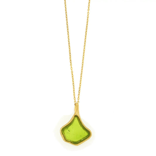 Necklace with a green glass pendant shaped like a ginkgo leaf on a gold chain against a white background