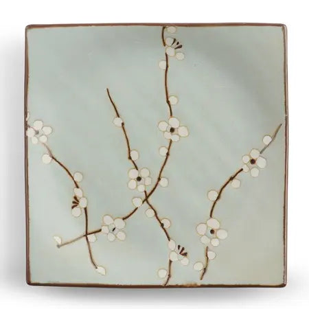 Soft blue square ceramic plate with a whte and brown floral design on a white background