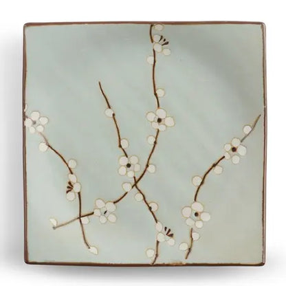 Soft blue square ceramic plate with a whte and brown floral design on a white background