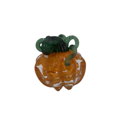 A glass pumpkin in translucent orange glass with a dark green stem, isolated on a plain white background.