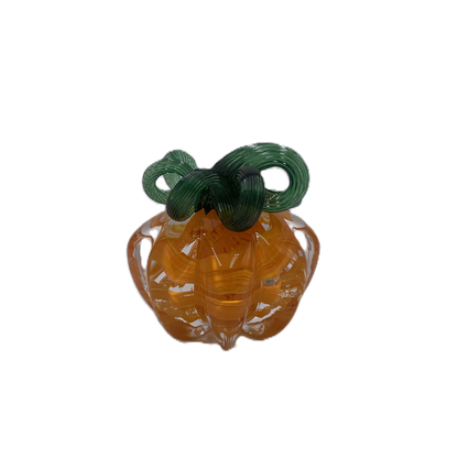A glass pumpkin in translucent orange glass with a dark green stem, isolated on a plain white background.