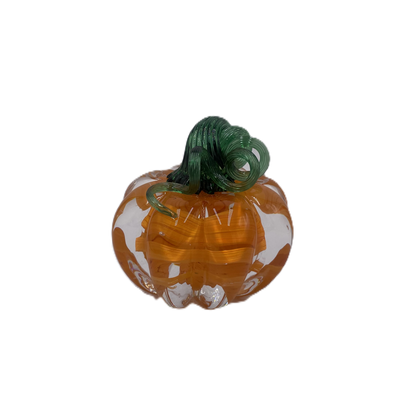 A glass pumpkin in translucent orange glass with a dark green stem, isolated on a plain white background.