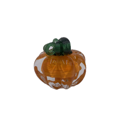 A glass pumpkin in translucent orange glass with a dark green stem, isolated on a plain white background.