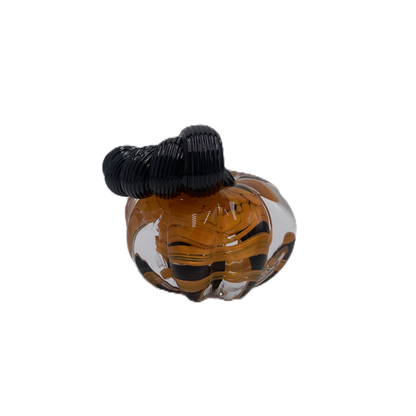A solid glass pumpkin, featuring a glossy black stem and swirling orange, black and clear glass body on a plain white background.