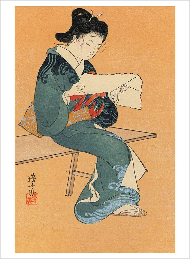 A Japanese woodblock print feauting a woman dressed in a blue kimono reading a piece of paper against a tan background.