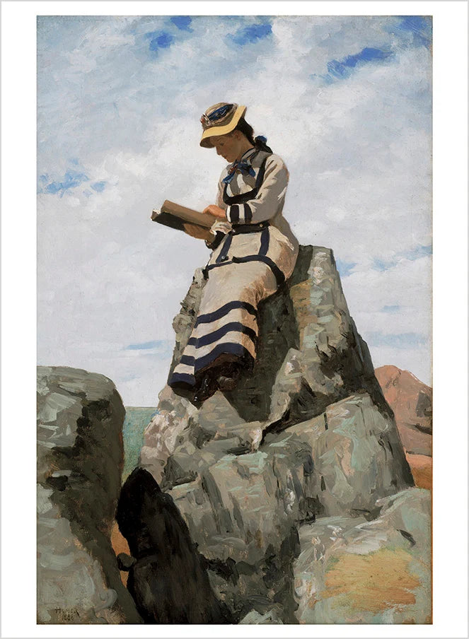 A woman dressed in a white and blue striped gown seated on a rock while reading a book against a cloudy sky