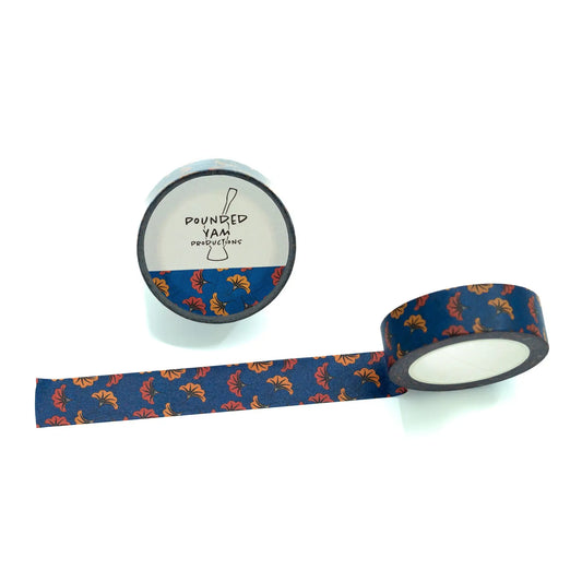 A roll of decorative washi tape with a navy blue background and a repeating pattern of orange and yellow abstract shapes, shown partially unrolled next to its branded cardboard core on a white background.