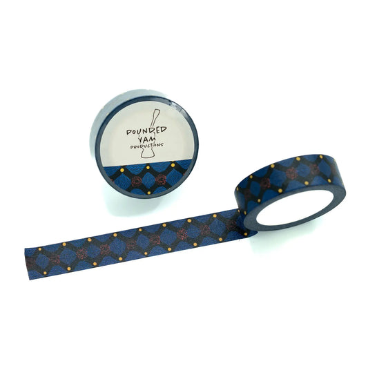 A roll of patterned washi tape with a dark blue background, featuring a geometric x design in navy and gold with small gold dots on a white background. 