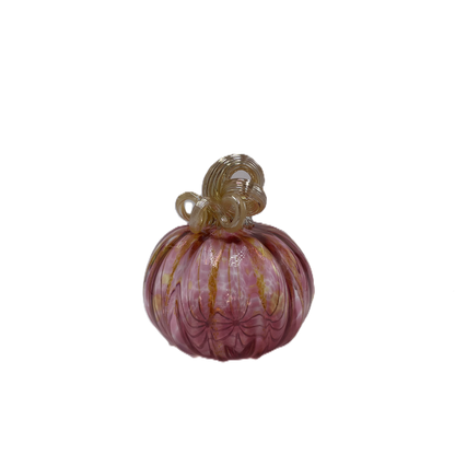 A hand-blown glass pumpkin with a pink body, accented by gold veins and a gold stem, isolated on a white background.