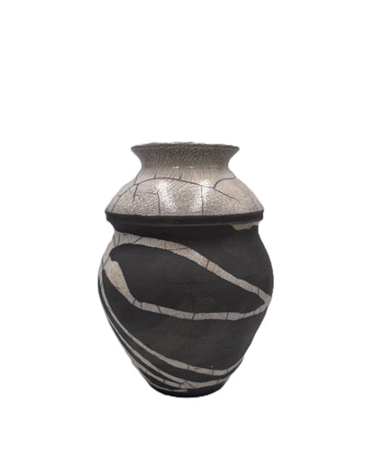 Decorative ceramic vessel with black and cream raku design on a white background