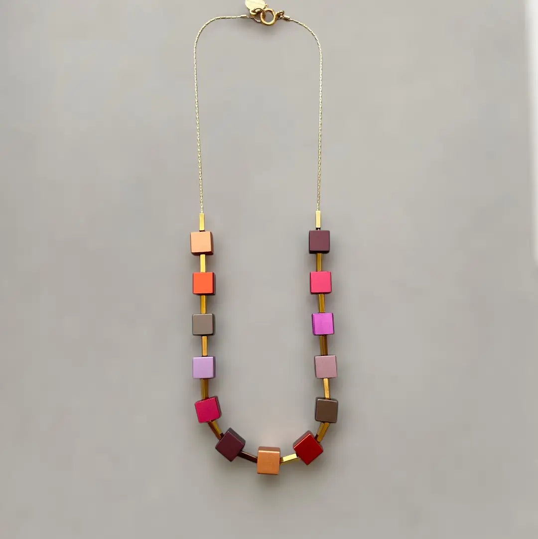 Necklace with colorful square beads on a gray background