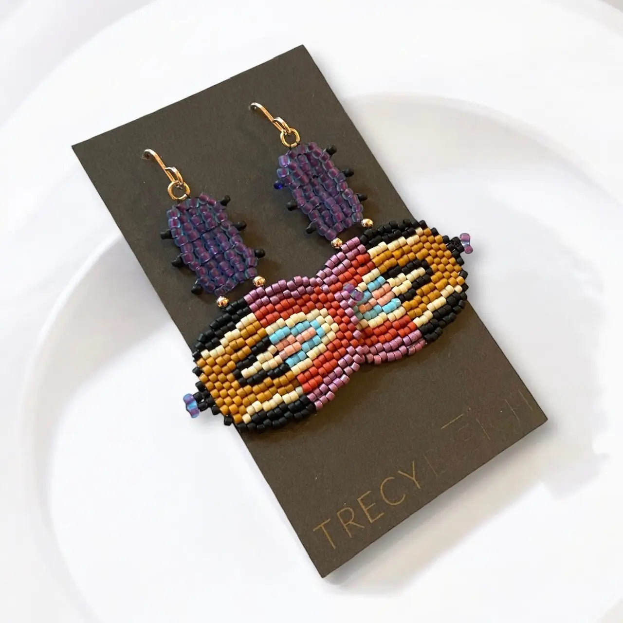 Colorful beaded earrings on a brown card with 'TRECY Bleich' branding.