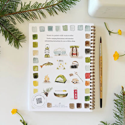 Notebook with watercolor illustrations on a white surface with decorative elements