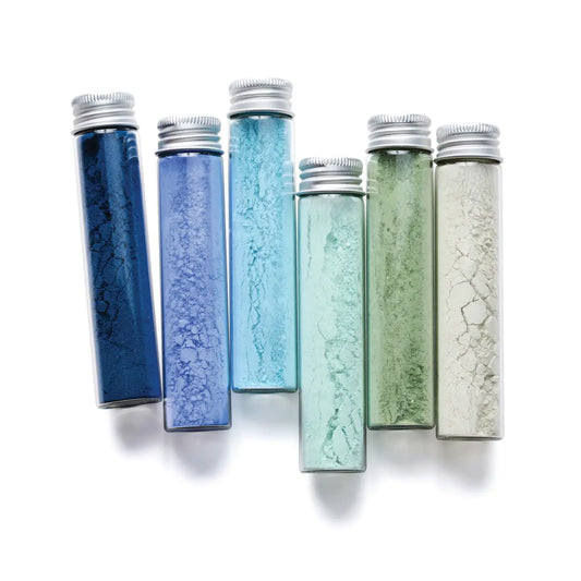 Set of six gradient-colored vials with silver caps on a white background